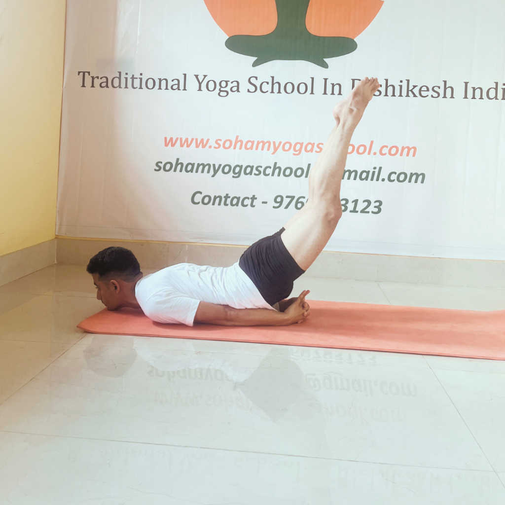 "A person performing Shalabhasana (Locust Pose), lying flat on their stomach with legs together, chin resting on the floor, and legs raised off the ground. The arms are placed by the sides, supporting the body while engaging the lower back muscles. The body remains straight and aligned in this yoga posture."